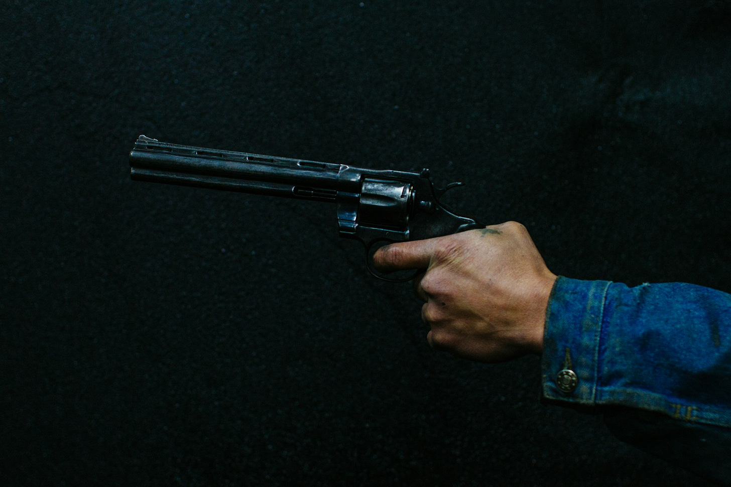 person holding revolver person holding revolver