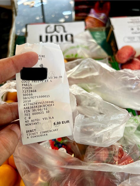 Photo 1 (busy market): Bustling outdoor farmers market under tree canopy with vendors in striped awnings and shoppers browsing produce Photo 2 (receipt): Hand holding a receipt showing 6 euros from a Paris market with bags of fresh produce visible in background Photo 3 (produce display): Colorful vegetable display at market stall featuring eggplants, cucumbers, celery, and ginger in wooden crates