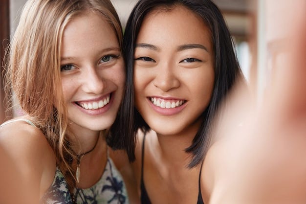 Happy european female embraces best asian friend, make selfie, stand close  to each other. | Free Photo