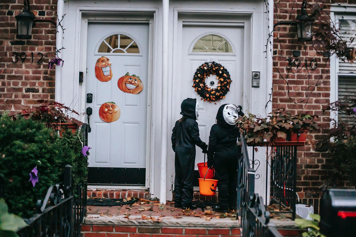 Two trick-or-treaters knocking on a neighbor's door Two trick-or-treaters knocking on a neighbor's door