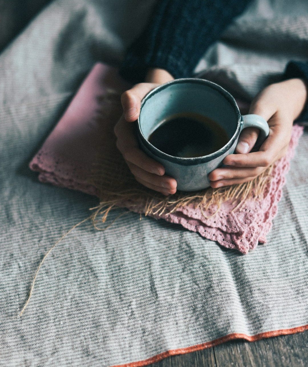 person holding green mug person holding green mug