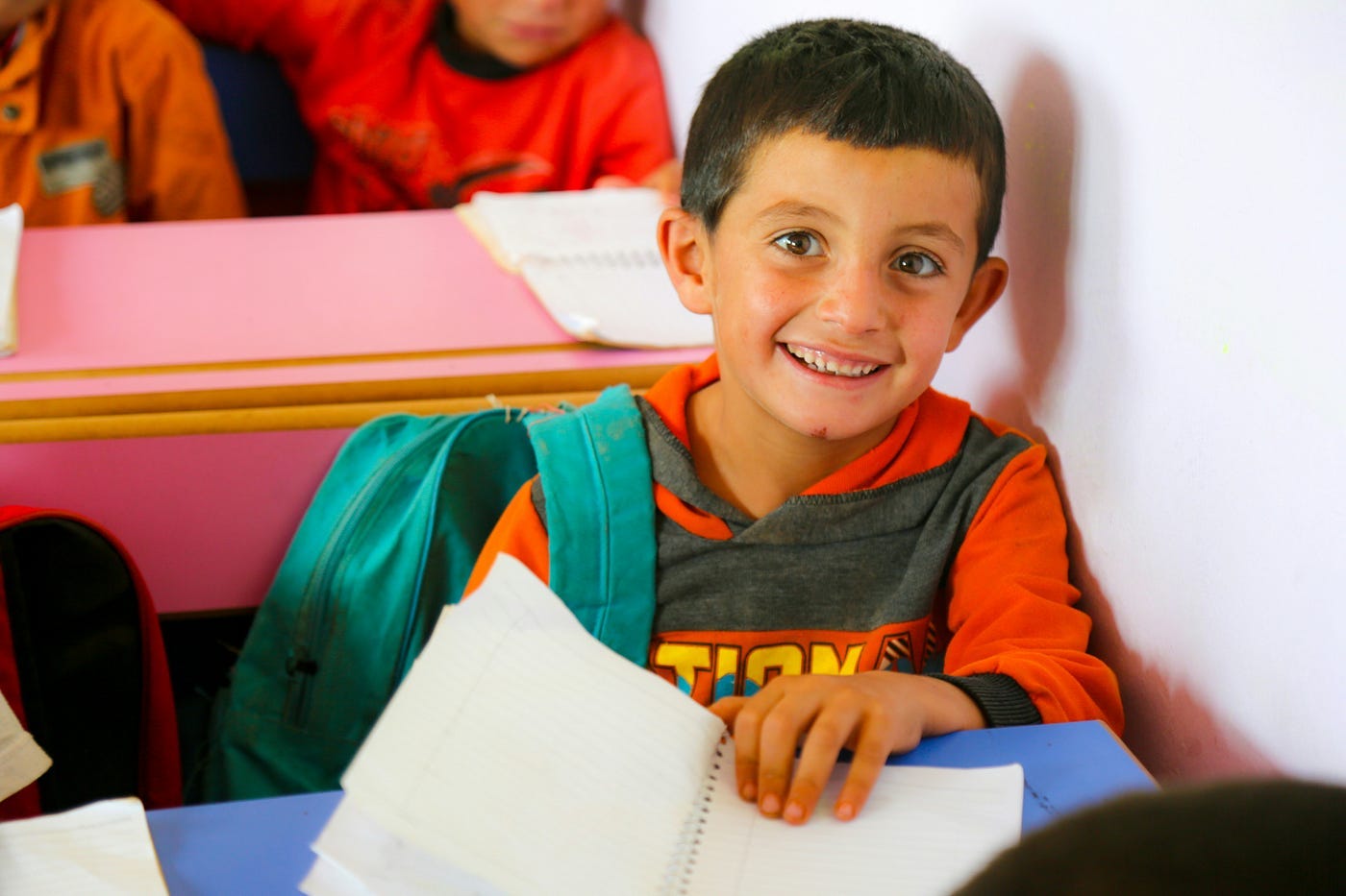 Young boy smiling doing school work at his desk Young boy smiling doing school work at his desk