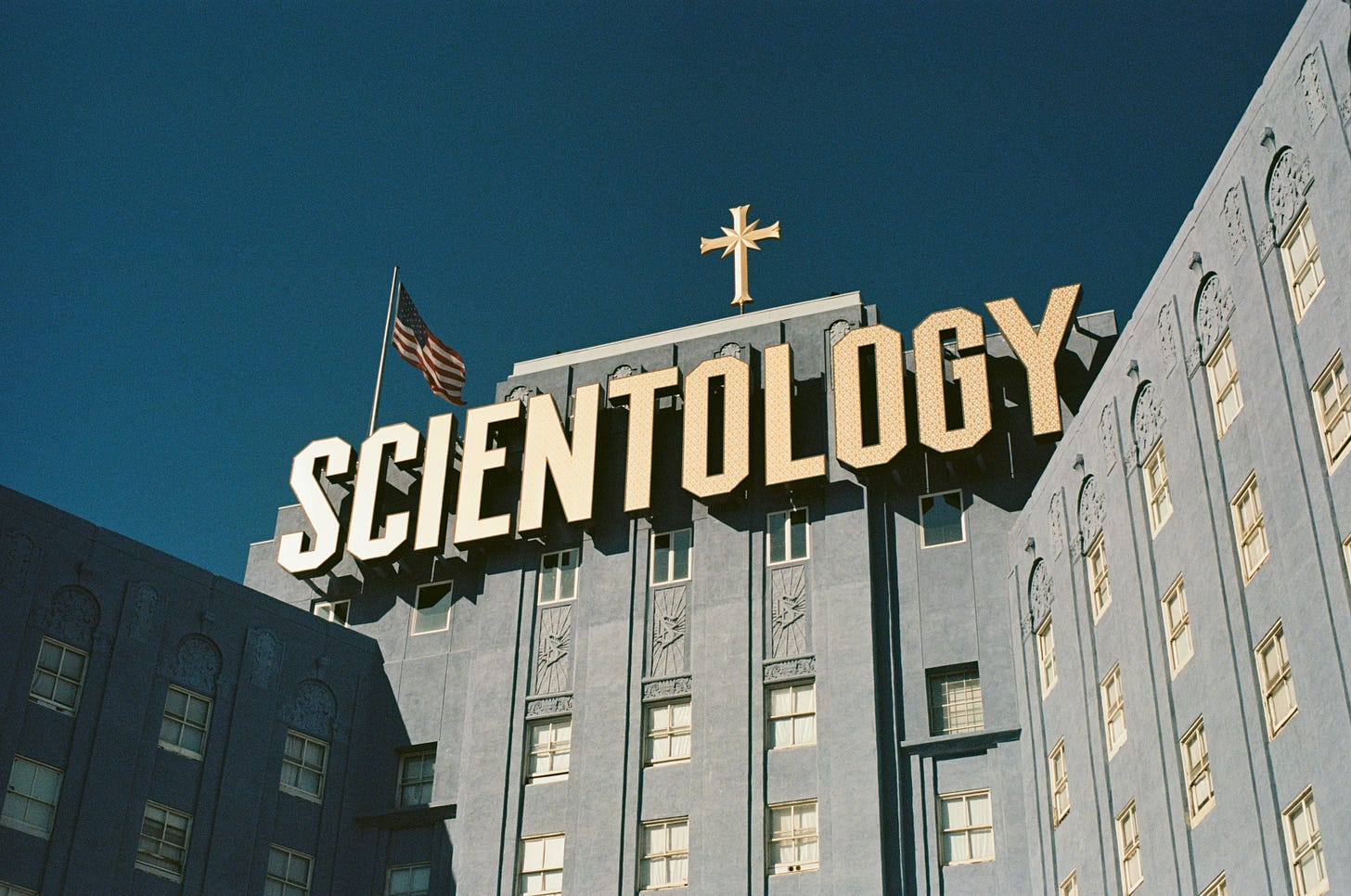 Scientology headquarters building illuminated at night, representing institutional structures that can create cult-like corporate cultures similar to those experienced in toxic workplace environments.