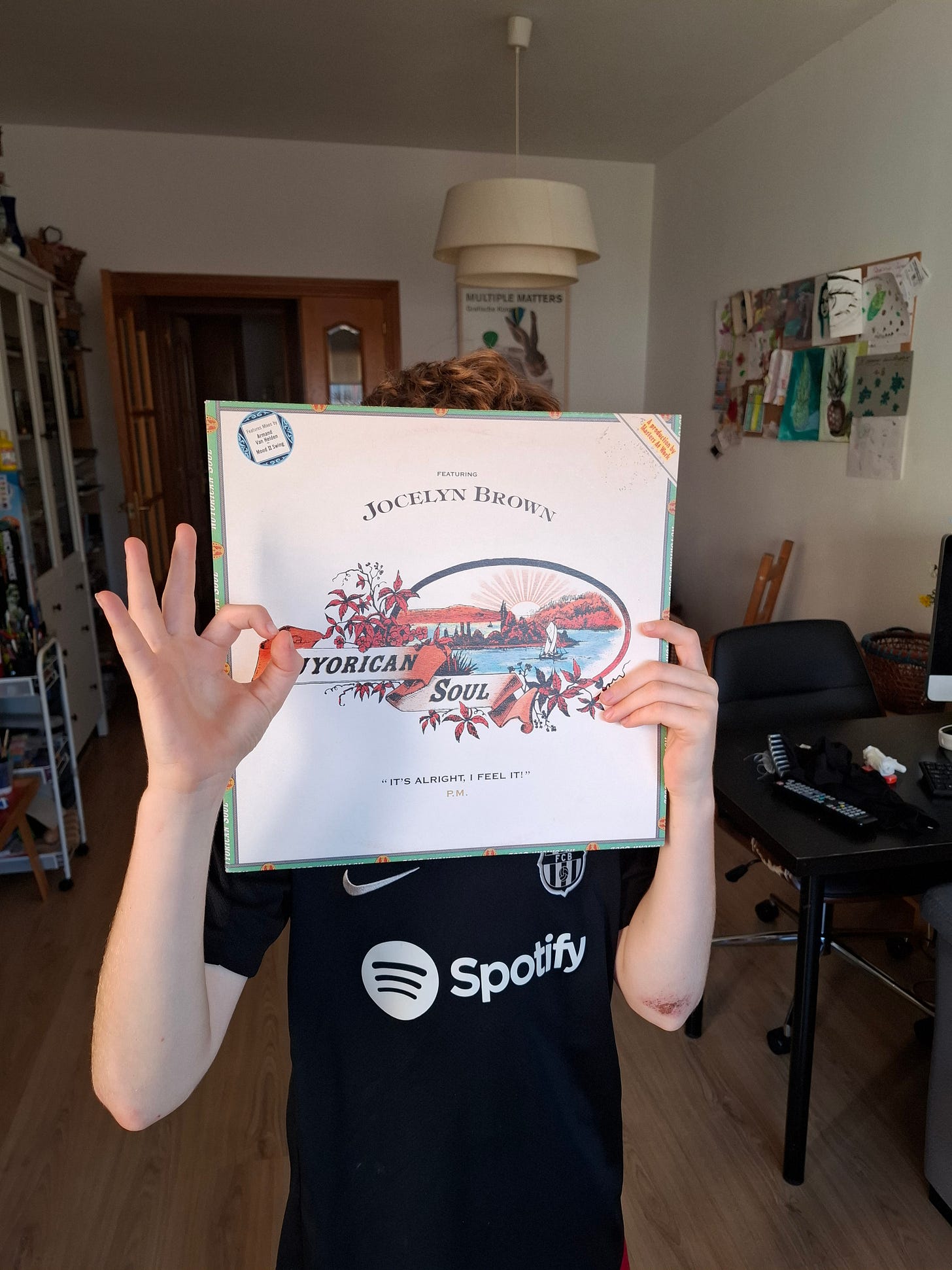 A child holds up a Nuyorican Soul record cover