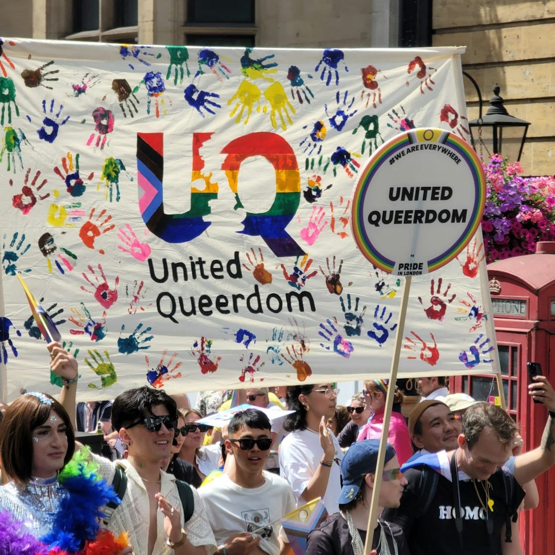 A group of people marching down a street holding a sign