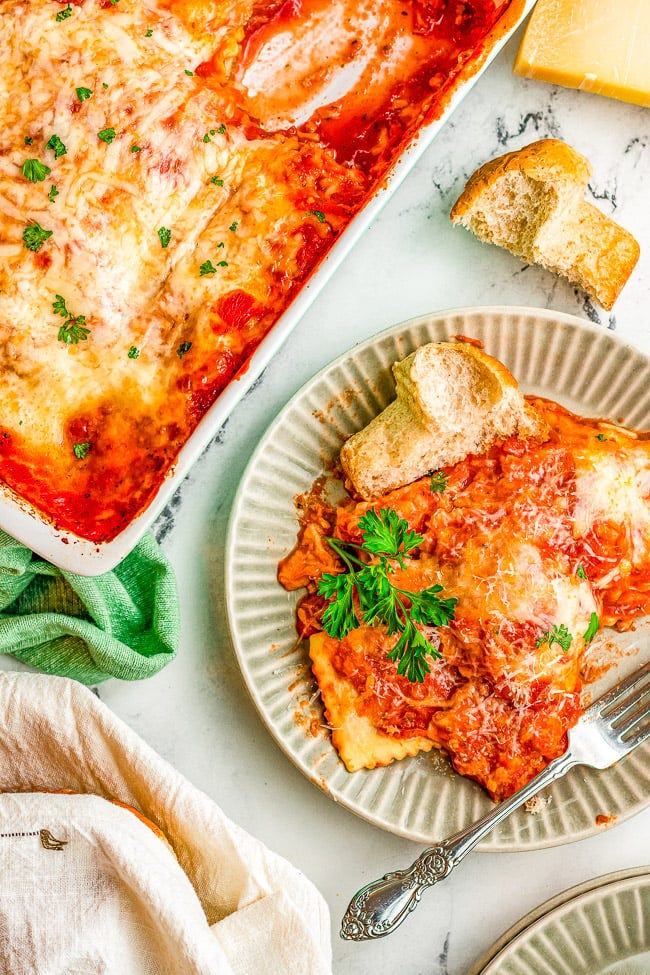 A dish of Cheesy Ravioli Lasagna and a serving on a plate with bread. 