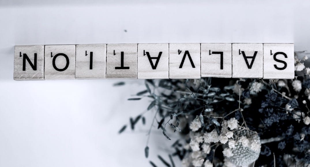 a wooden block that says salvation next to a bouquet of flowers