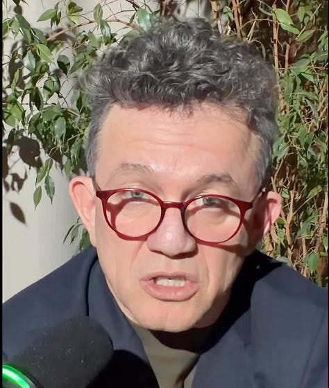 Berat Buzhala speaking on 27 February 2026, one day after the opening of Hashim Thaçi’s obstruction trial in The Hague. The expression oscillates between composure and strain, as he reflects publicly on dismissing employees while the legal storm intensifies.