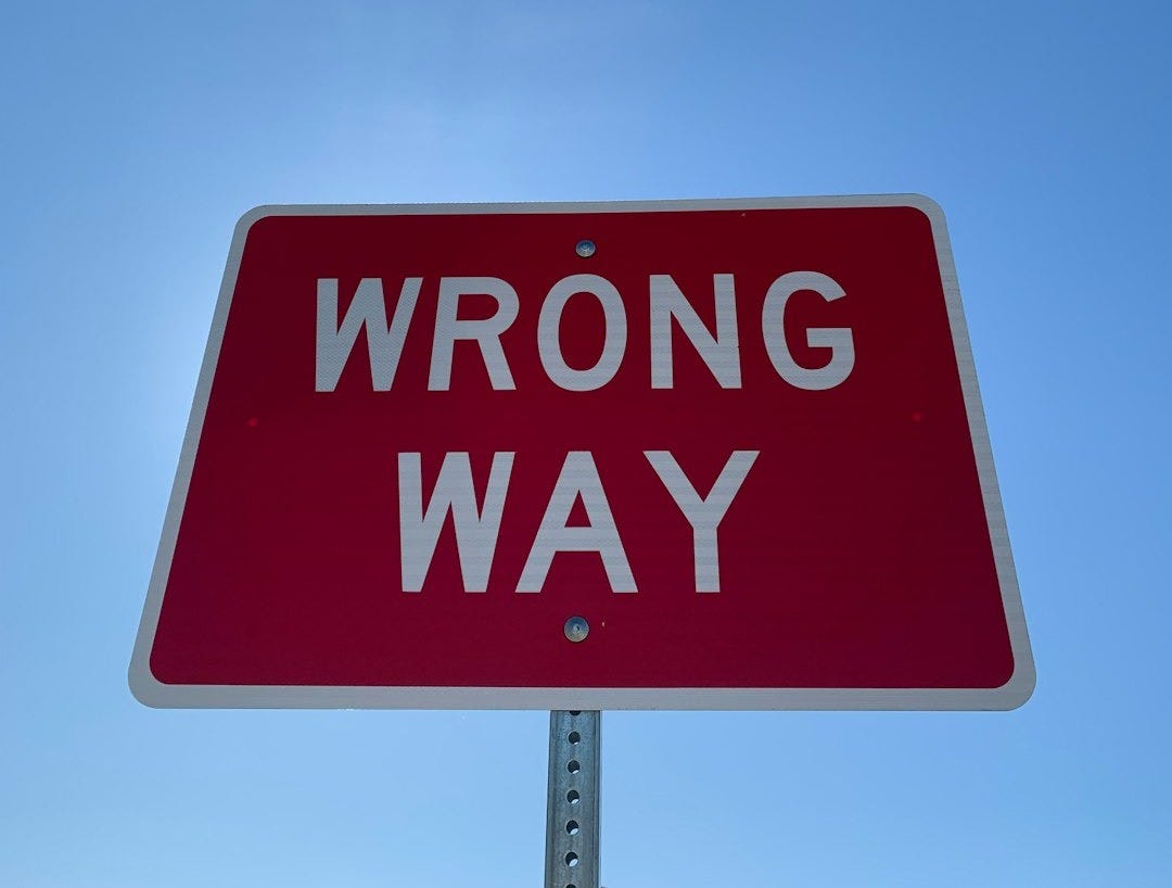 a red wrong way sign with a sky background a red wrong way sign with a sky background