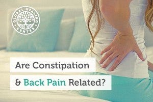 A woman holding her lower back. There are reports that harsh or minor constipation can cause back pain for individuals.