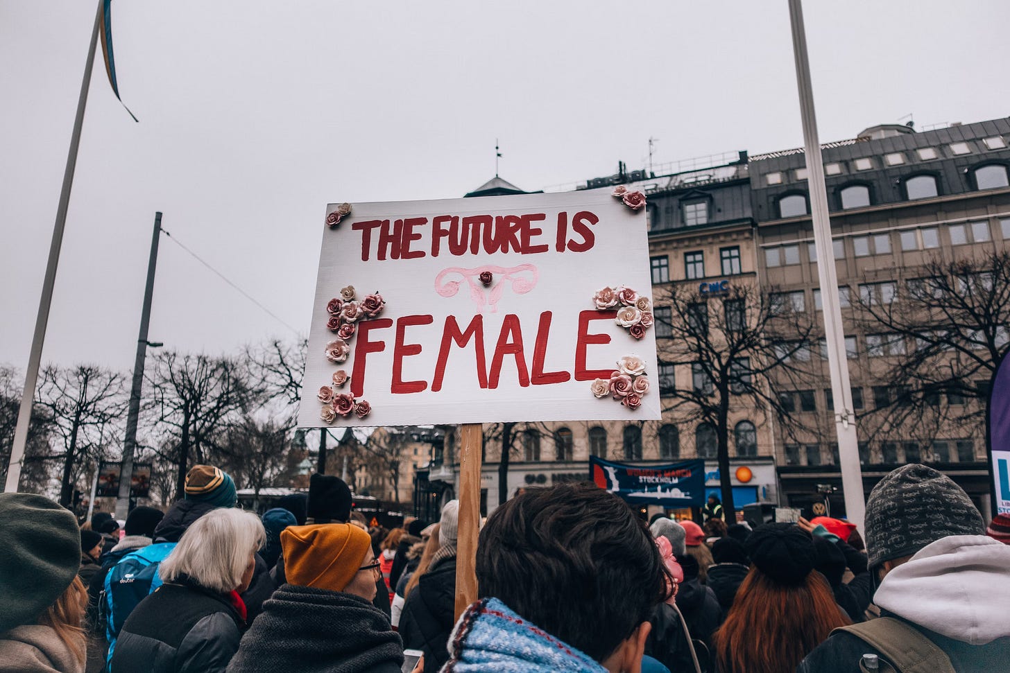 crowd and wooden sign that reads "the future is female"