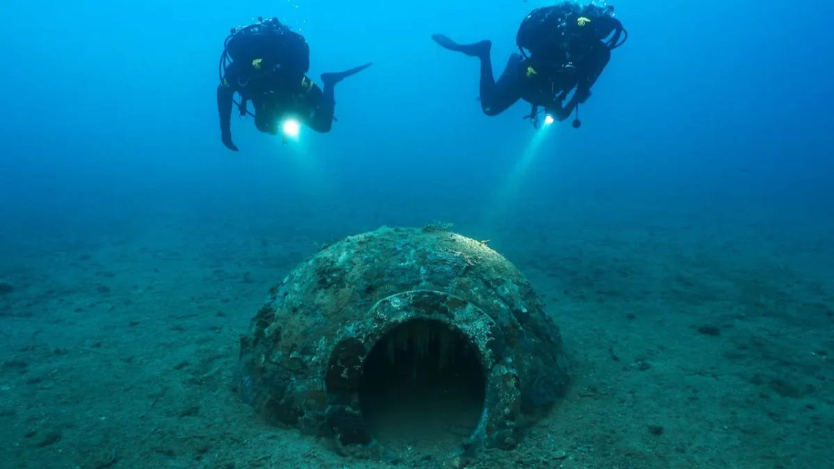 **Archaeologists with the dolium.** Credit: Soprintendenza Archeologia, Belle Arti e Paesaggio per le province di Pisa e Livorno **Archaeologists with the dolium.** Credit: Soprintendenza Archeologia, Belle Arti e Paesaggio per le province di Pisa e Livorno