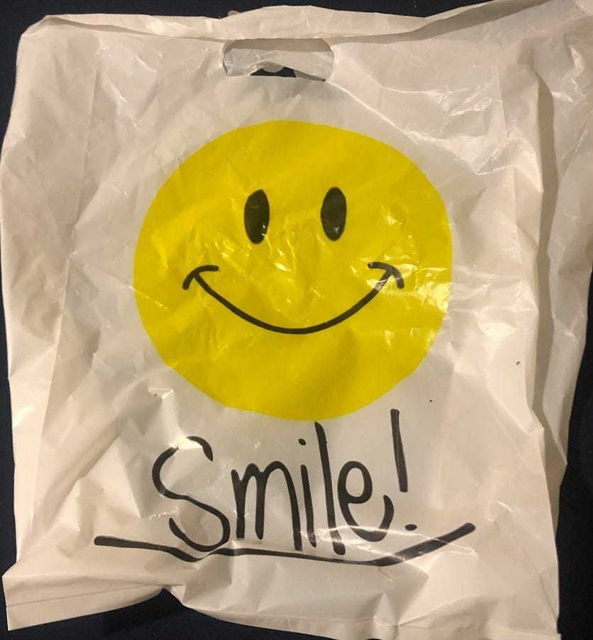 a white bag with a smiley face drawn on it