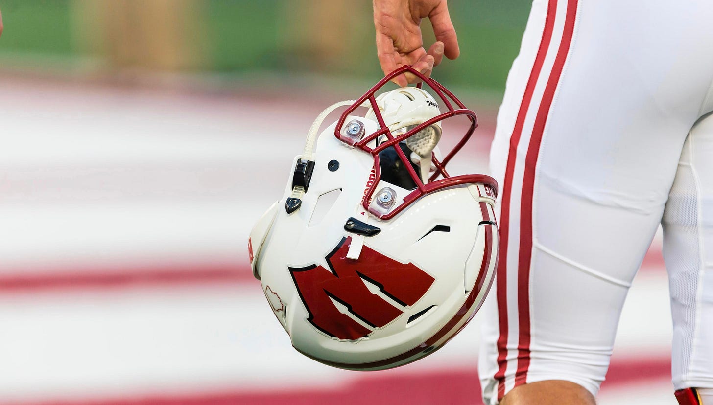 Wisconsin Badgers football player holding helmet on the sideline at Camp Randall Stadium. Wisconsin Badgers football player holding helmet on the sideline at Camp Randall Stadium.