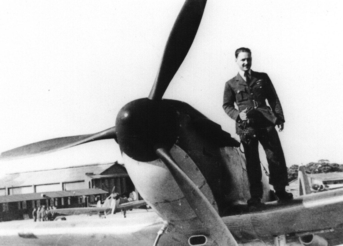 A man standinging on the wing of a military aircraft in the 1940s