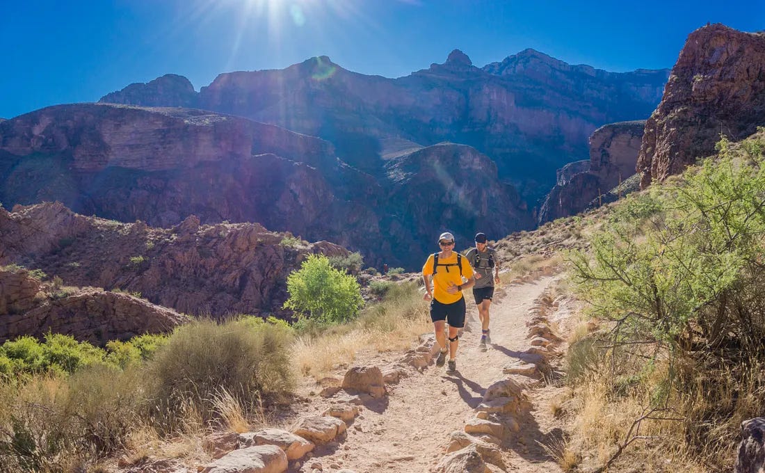 two people running in the mountains