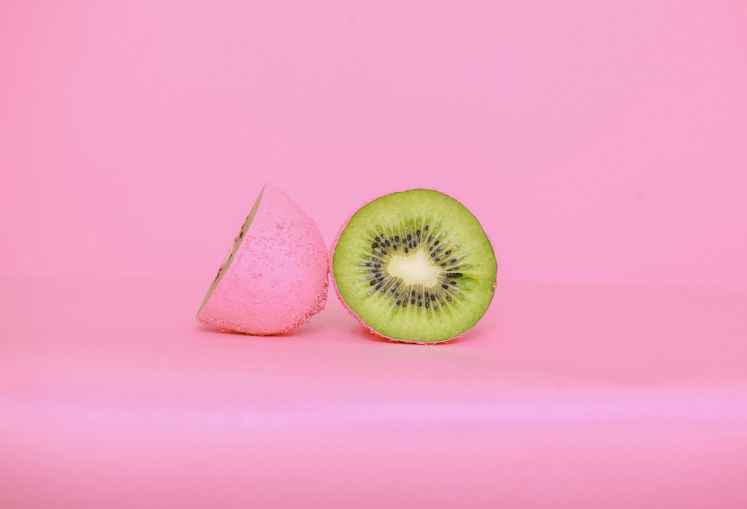 cut kiwi fruit on pink background
