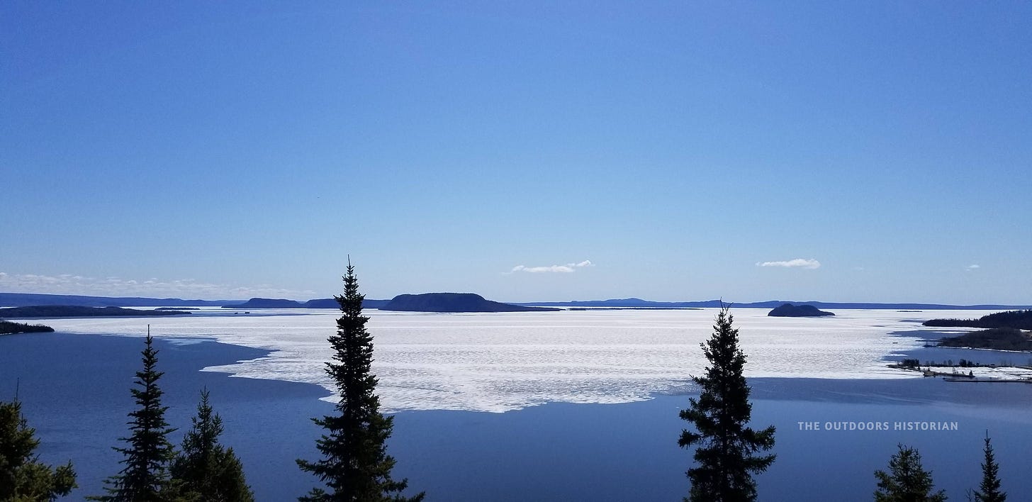A wide view of the Lake Superior Marine Conservation Area in early May with a sheet of ice still covering the water.