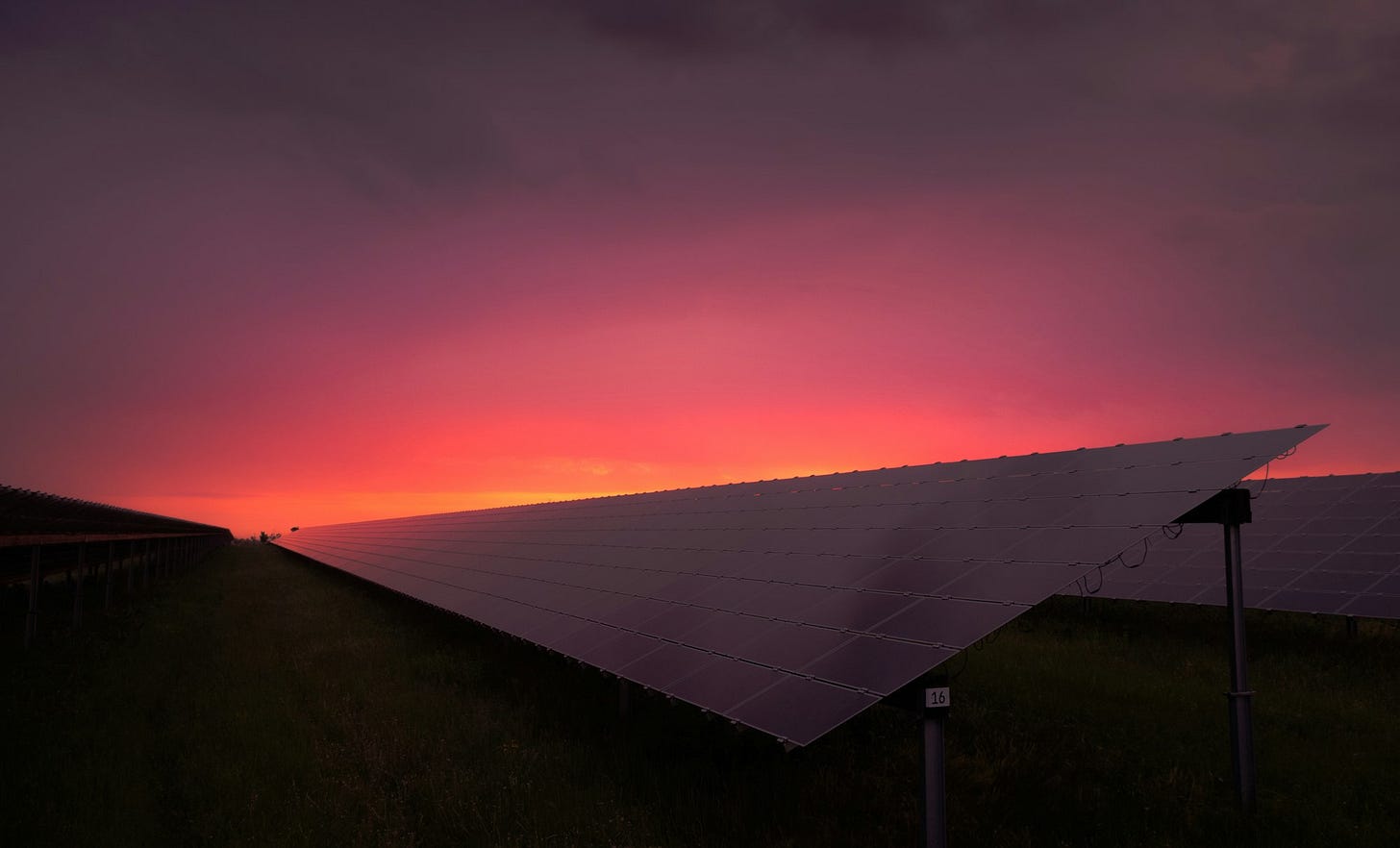 black solar panel under red and gray clouds as sunset