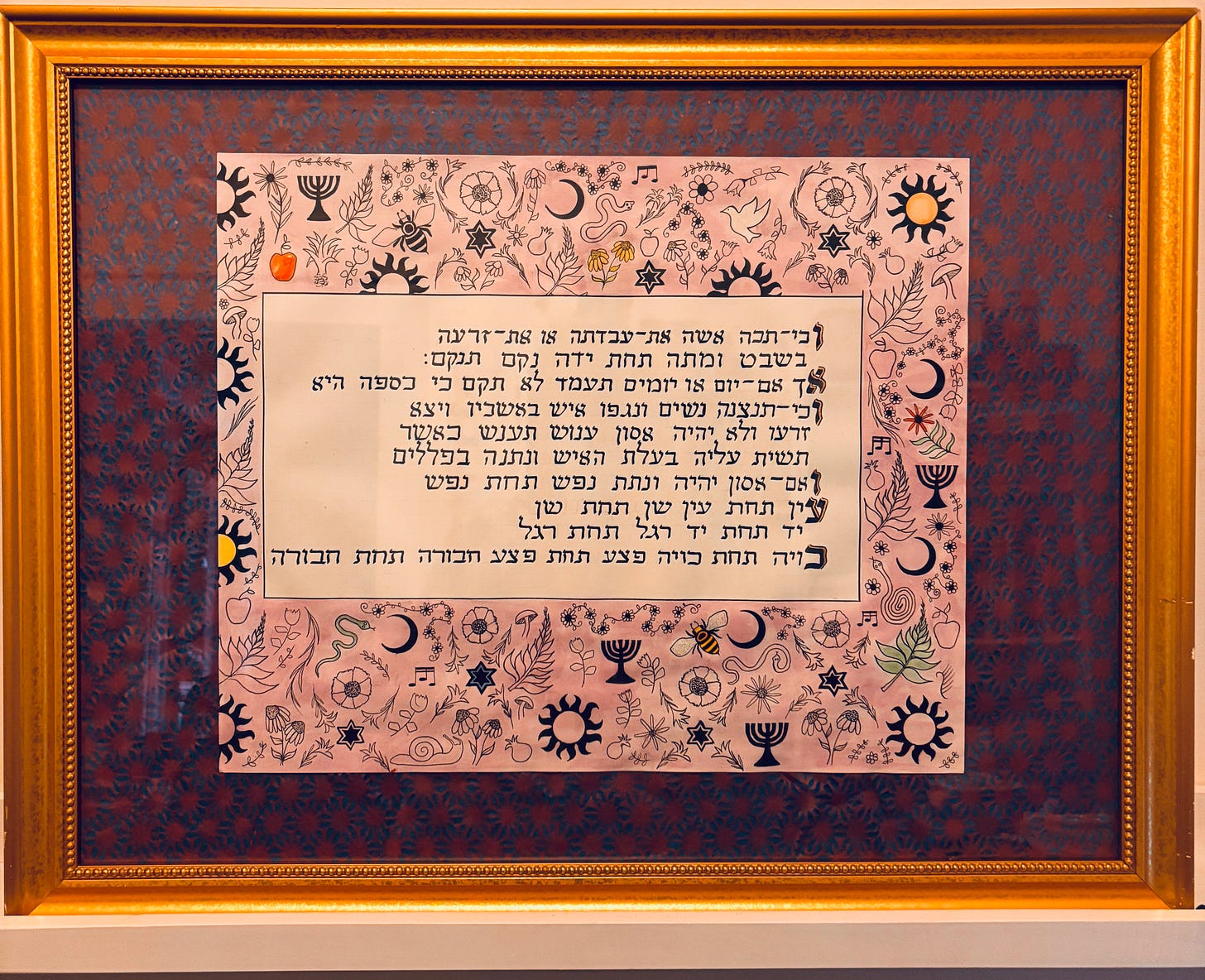 Hebrew words on a purple background suroounded by drawn images of snakes, bees, plants and cosmic images