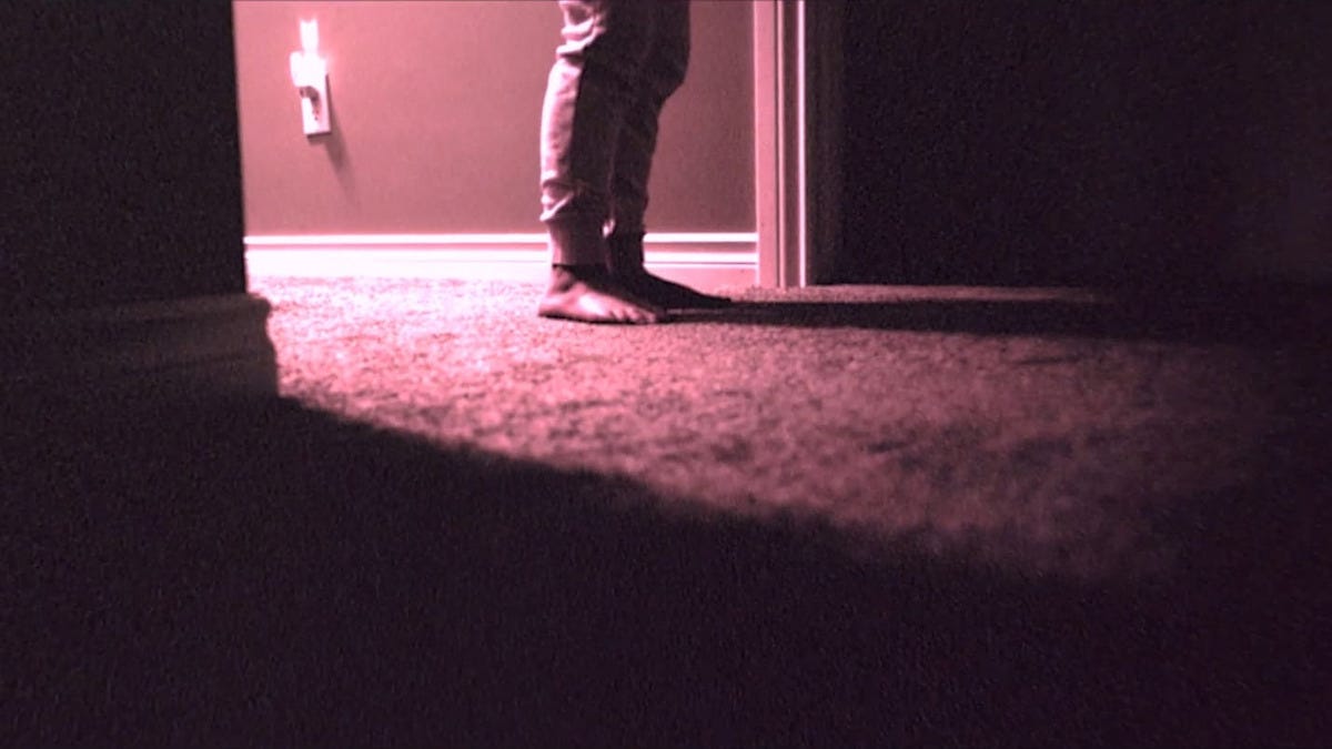 A shot from "Skinamarink" of bare feet on carpet