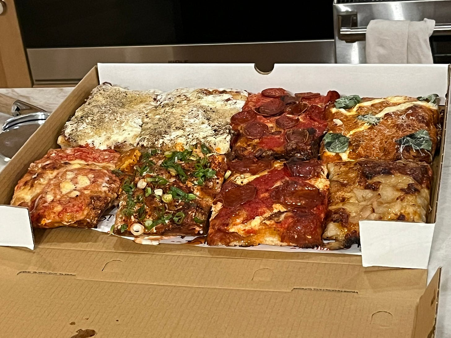 8 square pizza slices in a cardboard box
