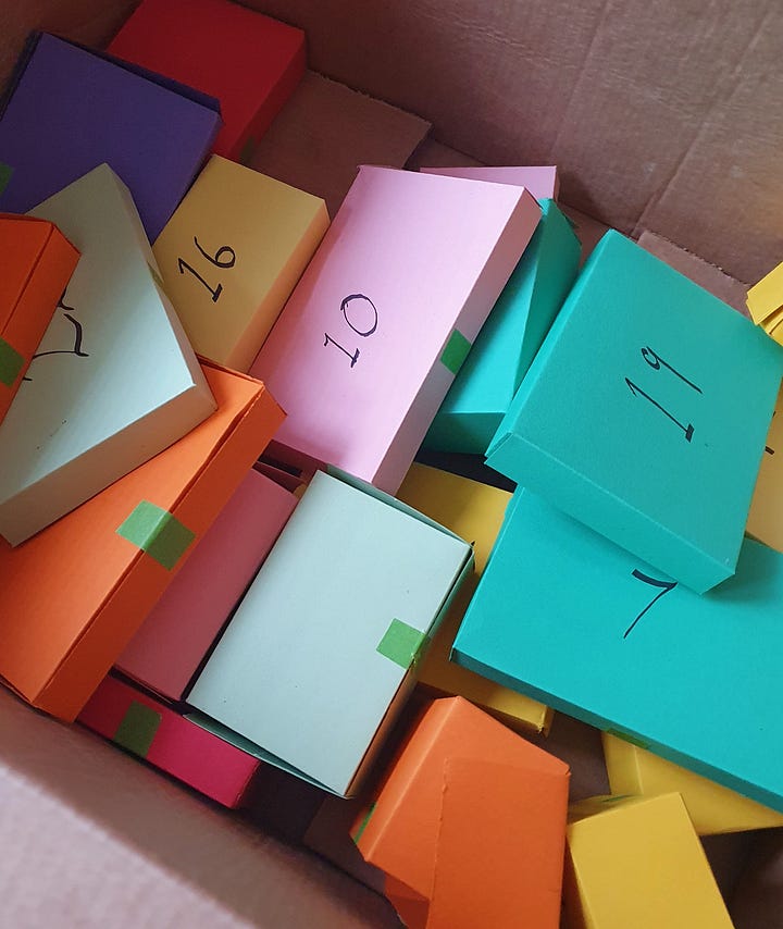 Two boxes filled with smaller colourful cardboxes