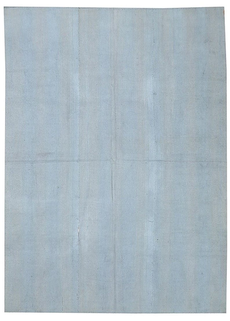 May include: A plain, light blue, textured fabric surface.