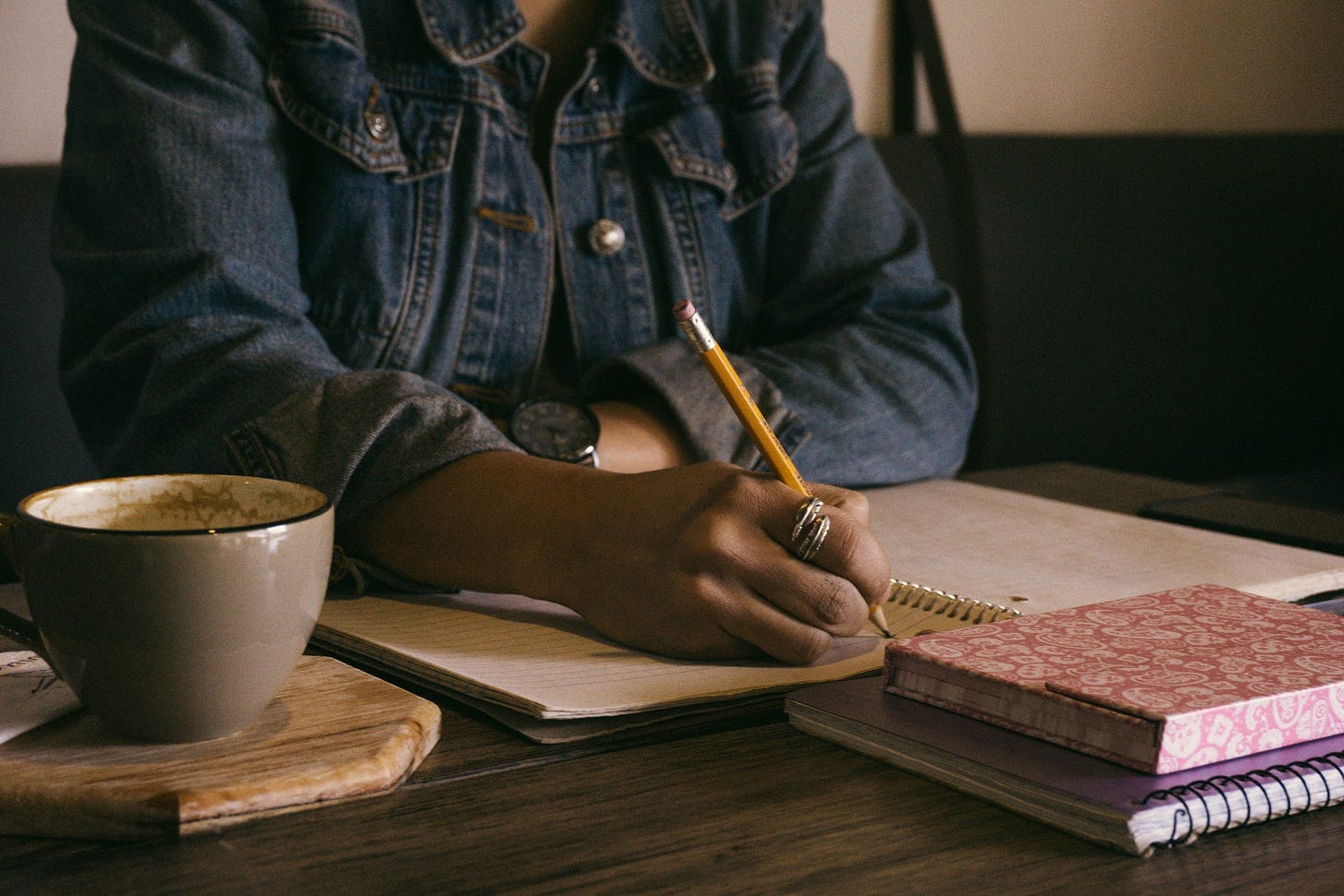 woman writing in notebook - Photo by Kat Stokes on Unsplash