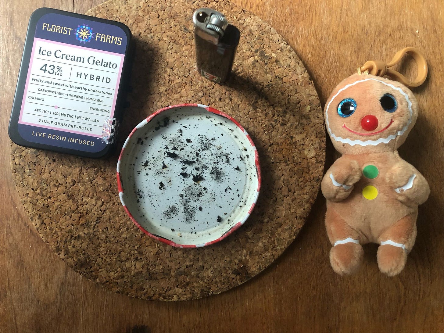 A pack of pre-rolls, a jam jar lid-turned-ashtray, a 7-Eleven lighter, and Cookie, my little gingerbread man