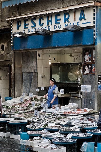 This may contain: people are standing in front of a fish market