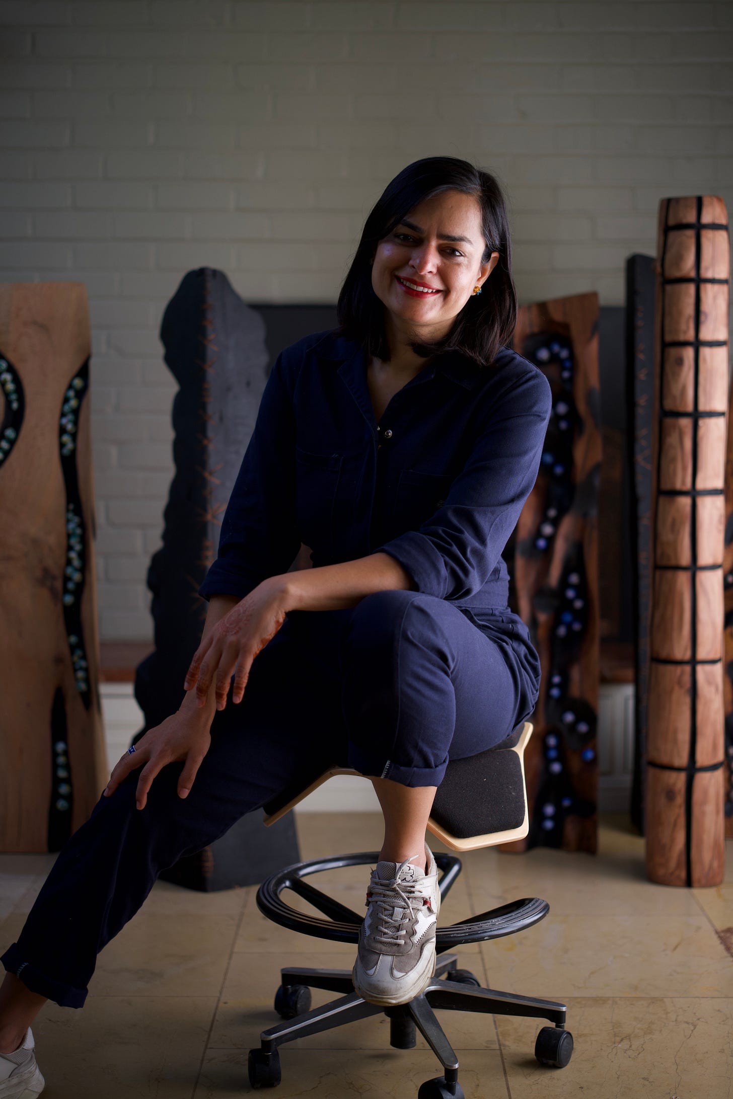 Sculptor Priyanka Rana in her studio surrounded by wooden sculptures Sculptor Priyanka Rana in her studio surrounded by wooden sculptures
