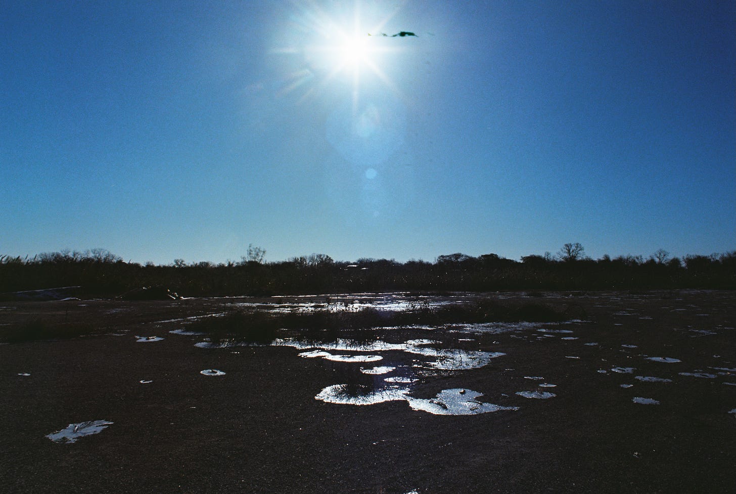 Morning sun over snow-swept industrial lot
