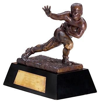 This may contain: a bronze statue of a football player on a black base with a gold plaque underneath it