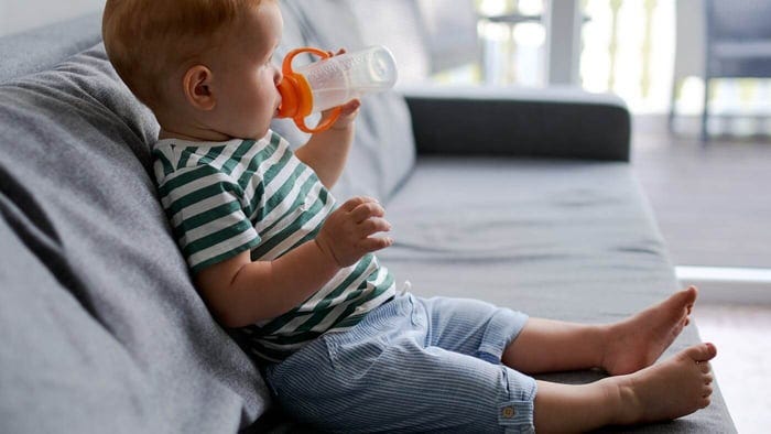Young boy drinking clear tap water. There are rising concerns about potential health risks from fluoridated drinking water.