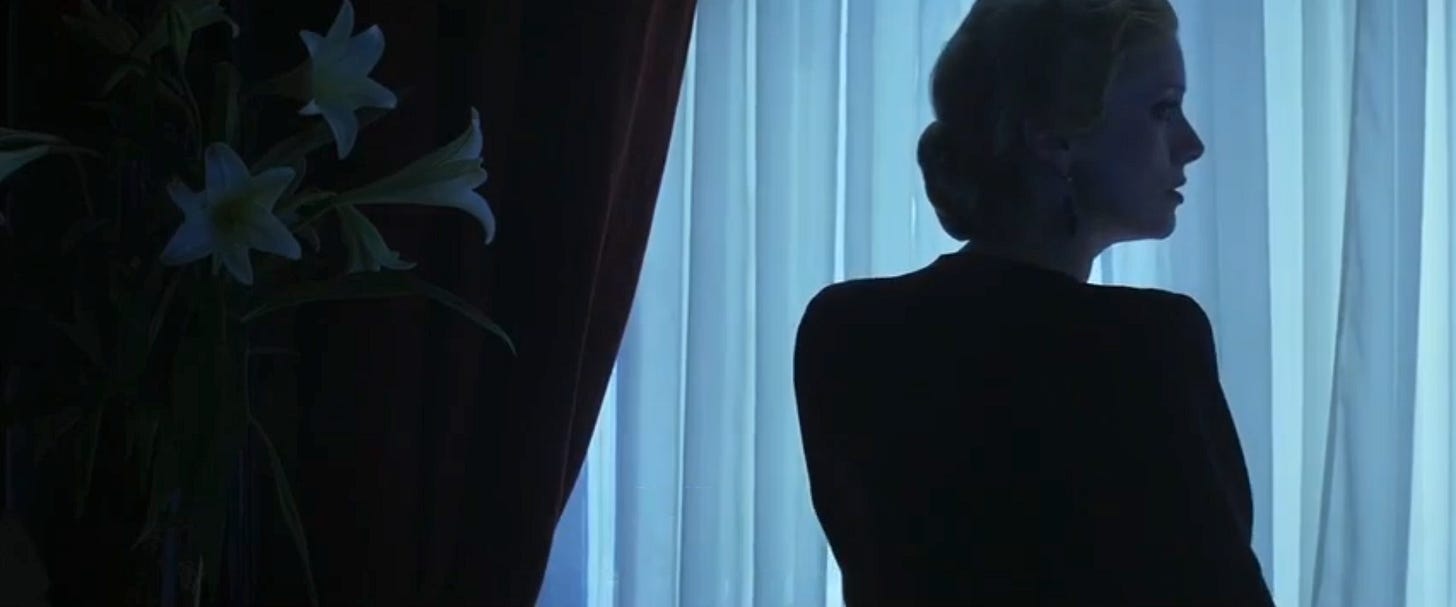 Amaryllis lillies and a silhouette of actress in front of white silk curtains