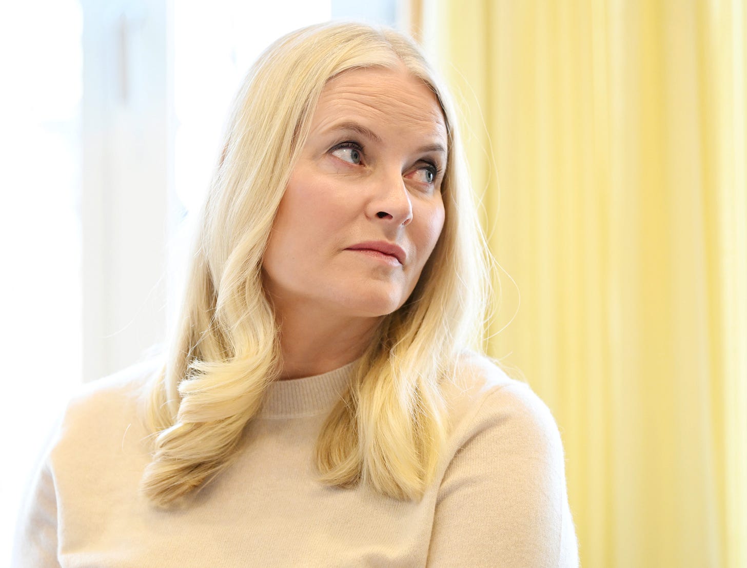 Princess Mette-Marit looking to the right in a cream jumper