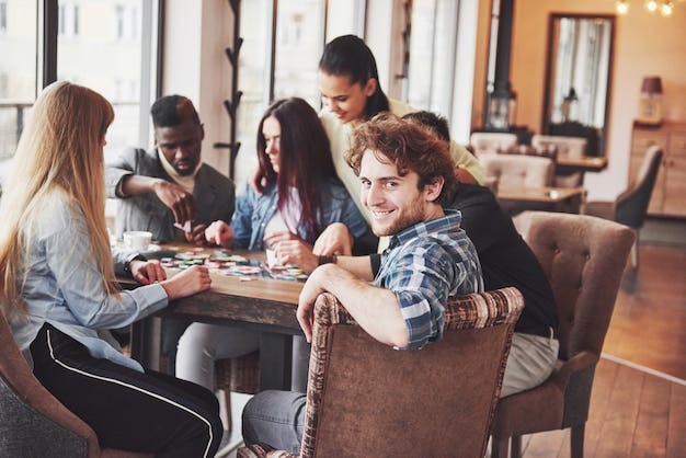 Premium Photo | Group of creative multietnic friends sitting at wooden ...