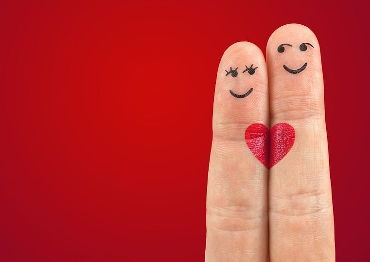 Foto de dedos indicador e médio juntos com rostos sorridentes e um coração desenhados, de modo a se parecerem com um casal, simbolizando amor e afeto em um fundo vermelho vibrante. Foto de dedos indicador e médio juntos com rostos sorridentes e um coração desenhados, de modo a se parecerem com um casal, simbolizando amor e afeto em um fundo vermelho vibrante.