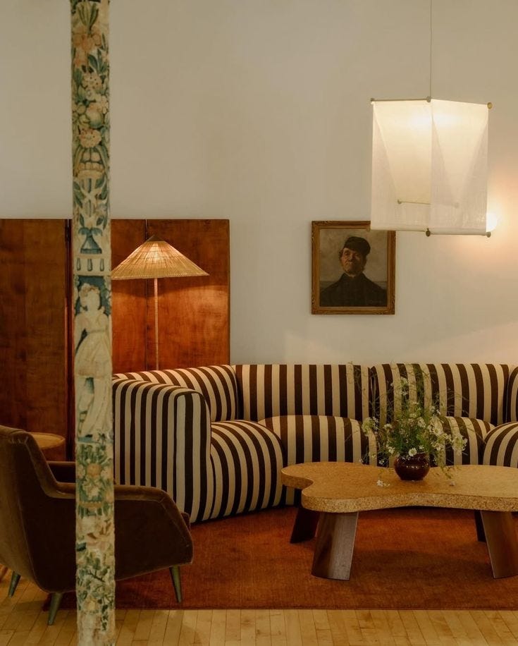 This may contain: a living room filled with furniture and a painting on the wall