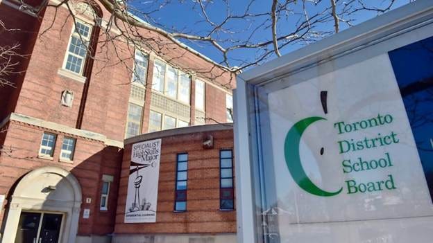 A Toronto District School Board logo is seen on a sign in front of a high school in Toronto