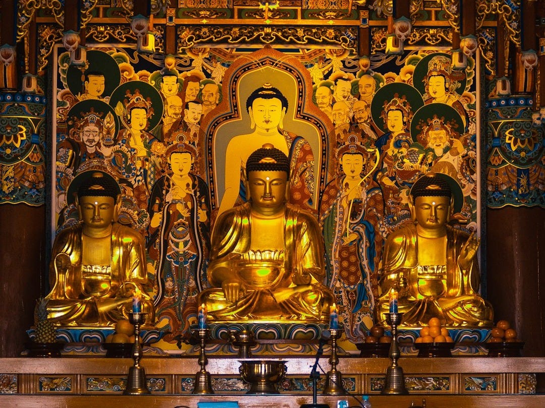 a group of gold statues in a room with a wall of colorful walls
