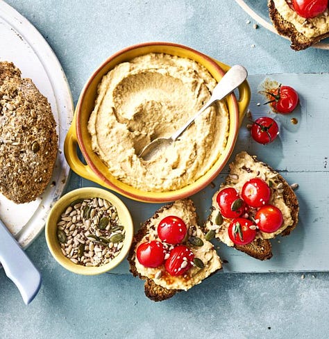 9 different plates of hummus with varying toppings from meatballs to lentils