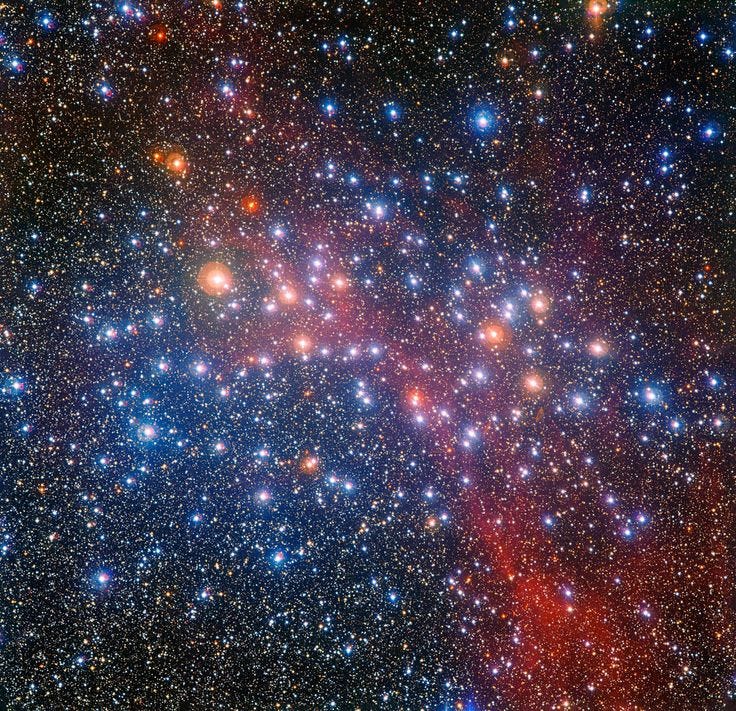 This may contain: the large cluster of stars is shown in this image from space, with bright blue and red colors