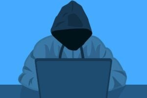 hooded figure at laptop