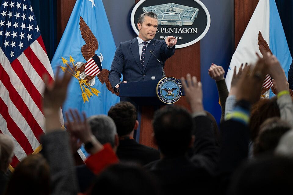 https://commons.wikimedia.org/wiki/File:260313-D-VQ832-1494_SecWar,_CJCS_Conduct_Pentagon_Press_Briefing_13_MARCH_2026.jpg
