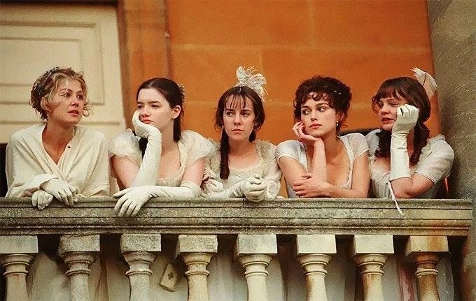 This may contain: four women dressed in period clothing standing on a balcony