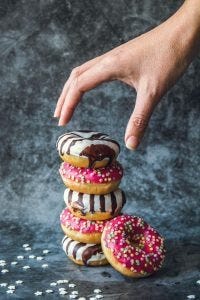 hand reaching for a stack of donuts