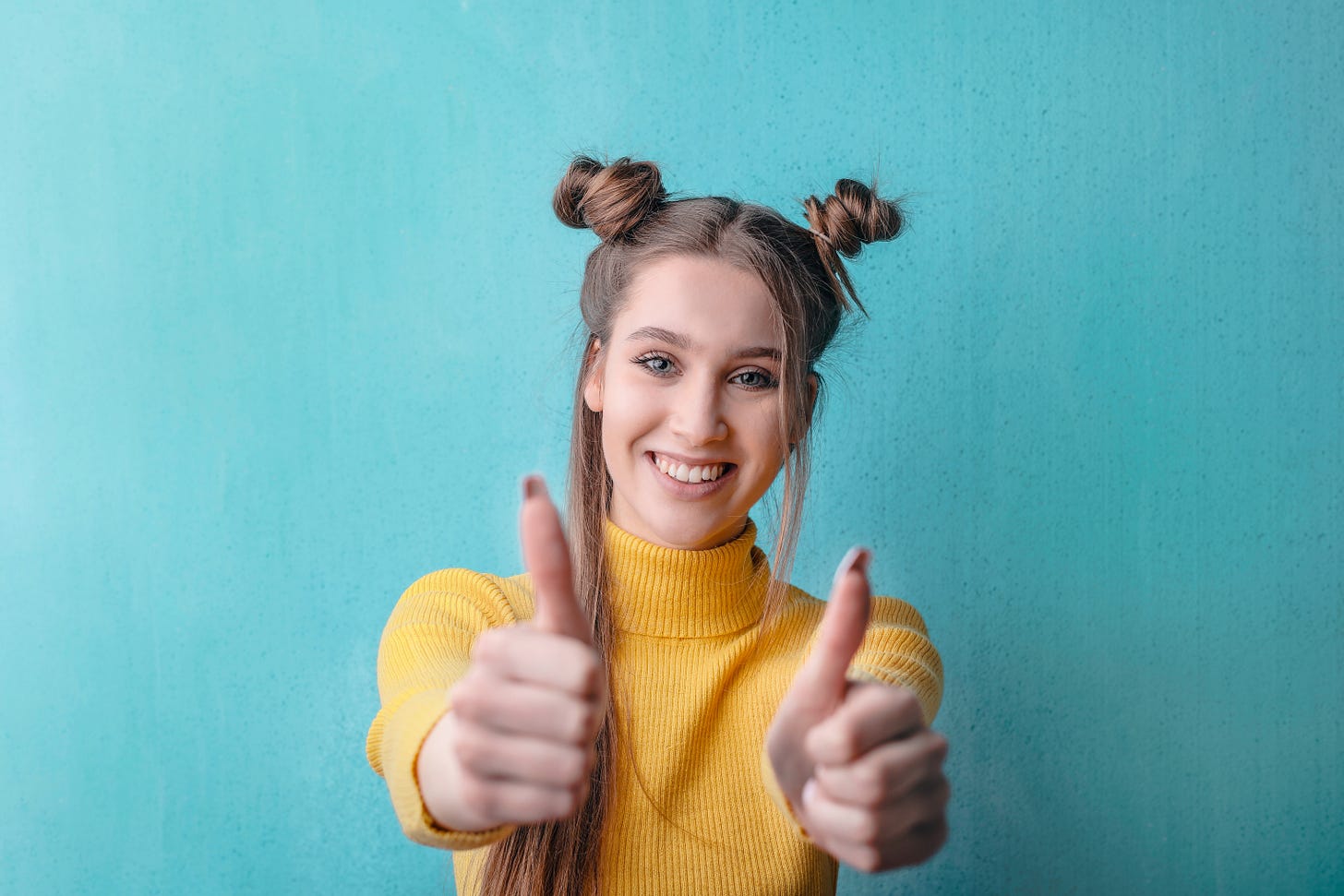 woman happy giving thumbs up on a green background in a pink tshirt