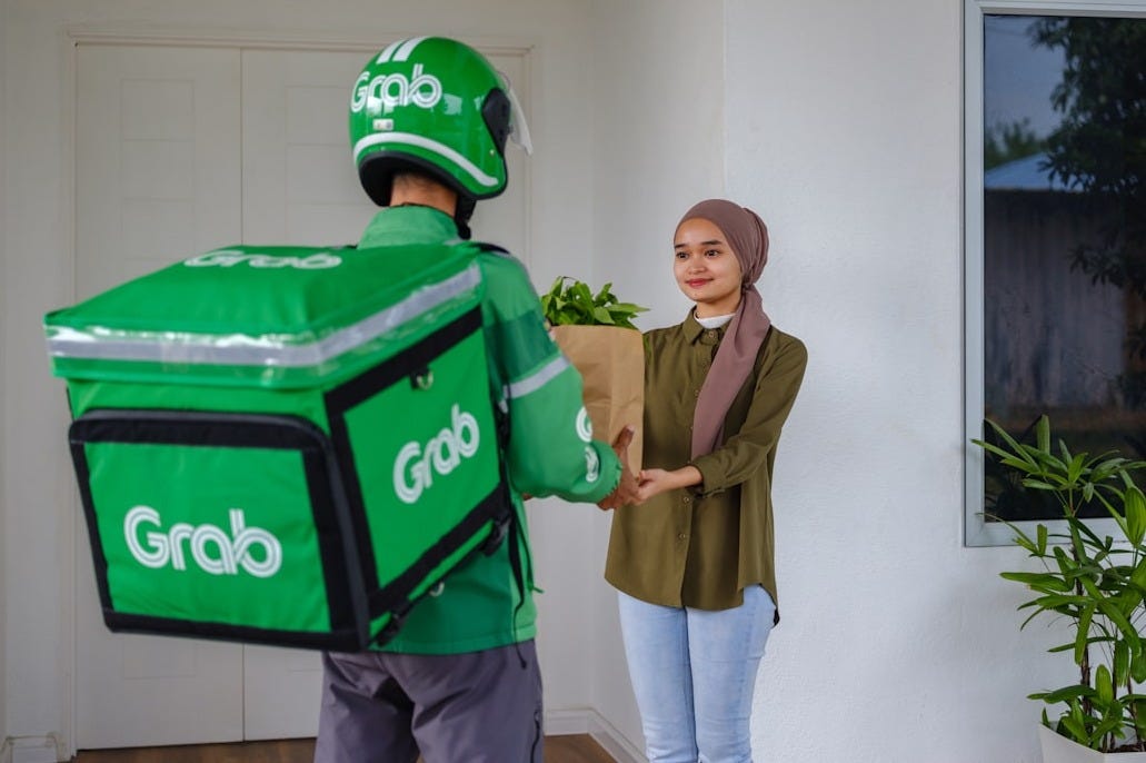 a man and a woman holding a giant green box